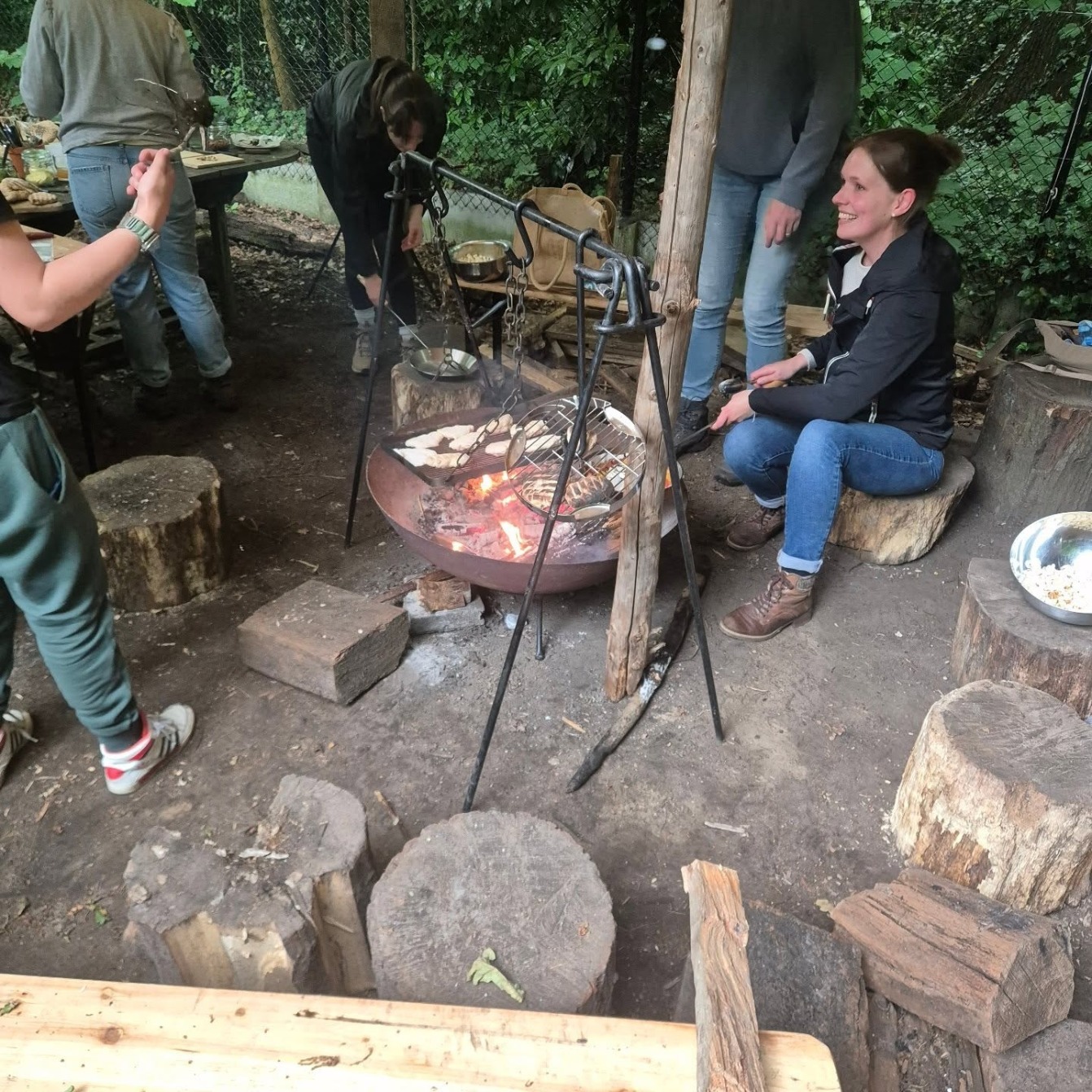 Gezellige groep rond kampvuur bij Studijo Bos